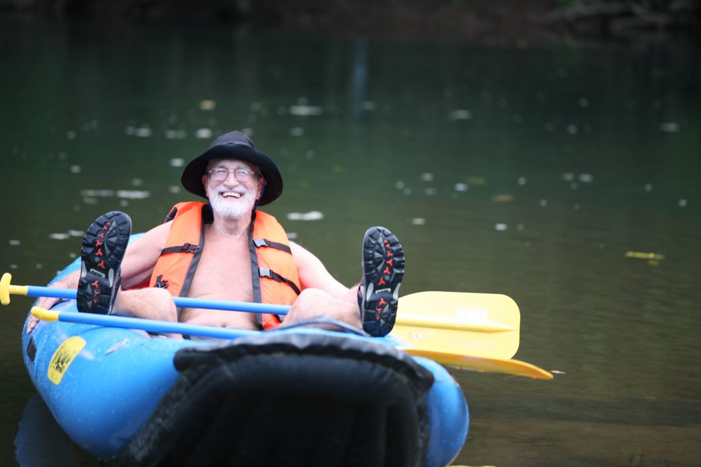 Man smiling slouching on boat on a river